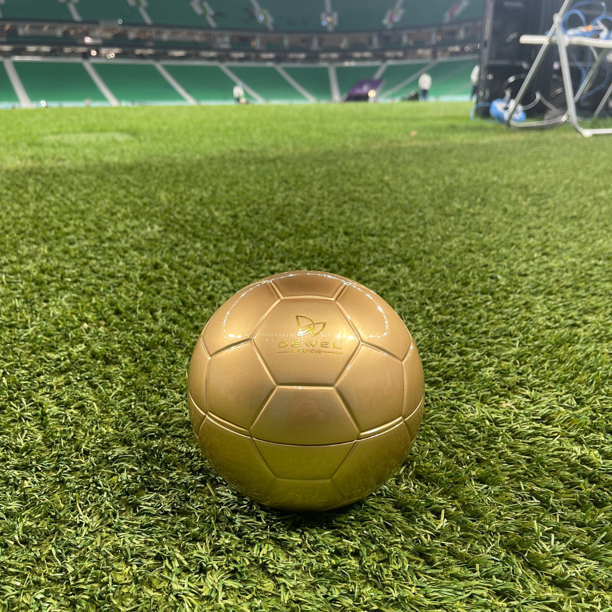 Gold soccer ball on a green artificial turf field
