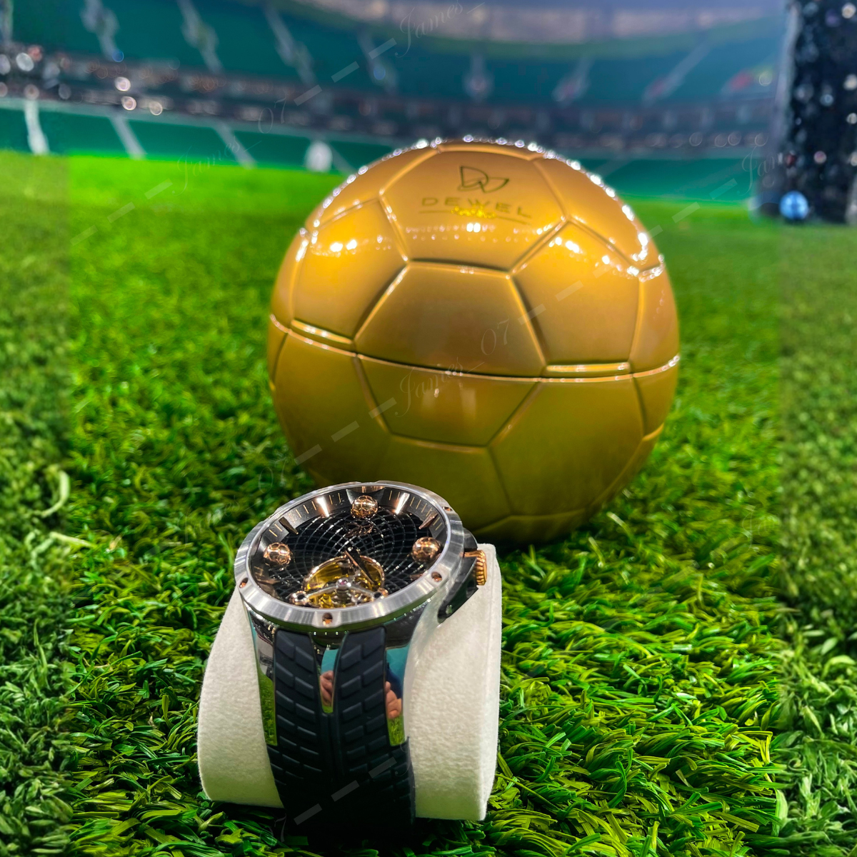 Gold soccer ball and watch on grass with stadium background